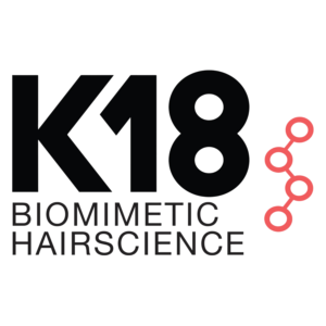 K18 Biomimetic Hairscience logo with bold black text and a pink molecular structure graphic on a light background. Salon Noir in Cedarburg, WI -