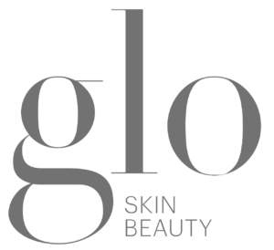 Logo for Glo Skin Beauty, featuring the word "glo" in large gray serif font and "SKIN BEAUTY" in smaller gray sans-serif font beneath it, all on a white background. Salon Noir in Cedarburg, WI -